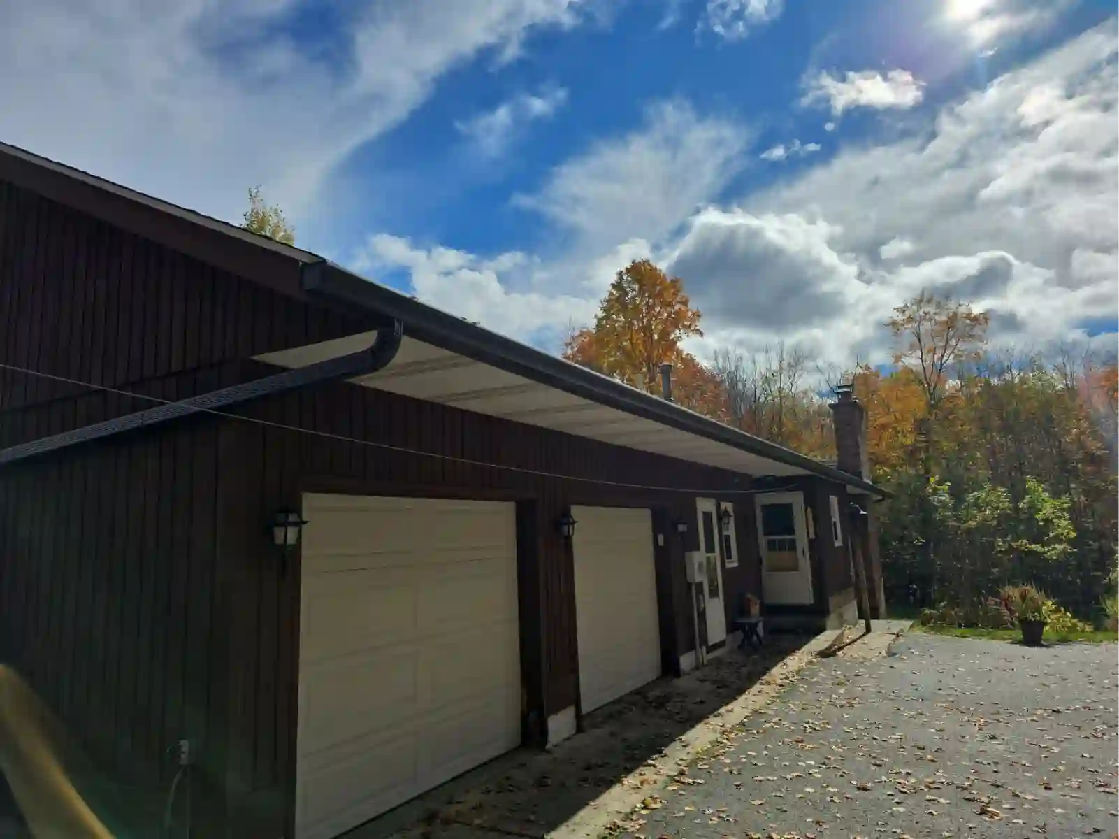 Roofline with new gutters against fall color