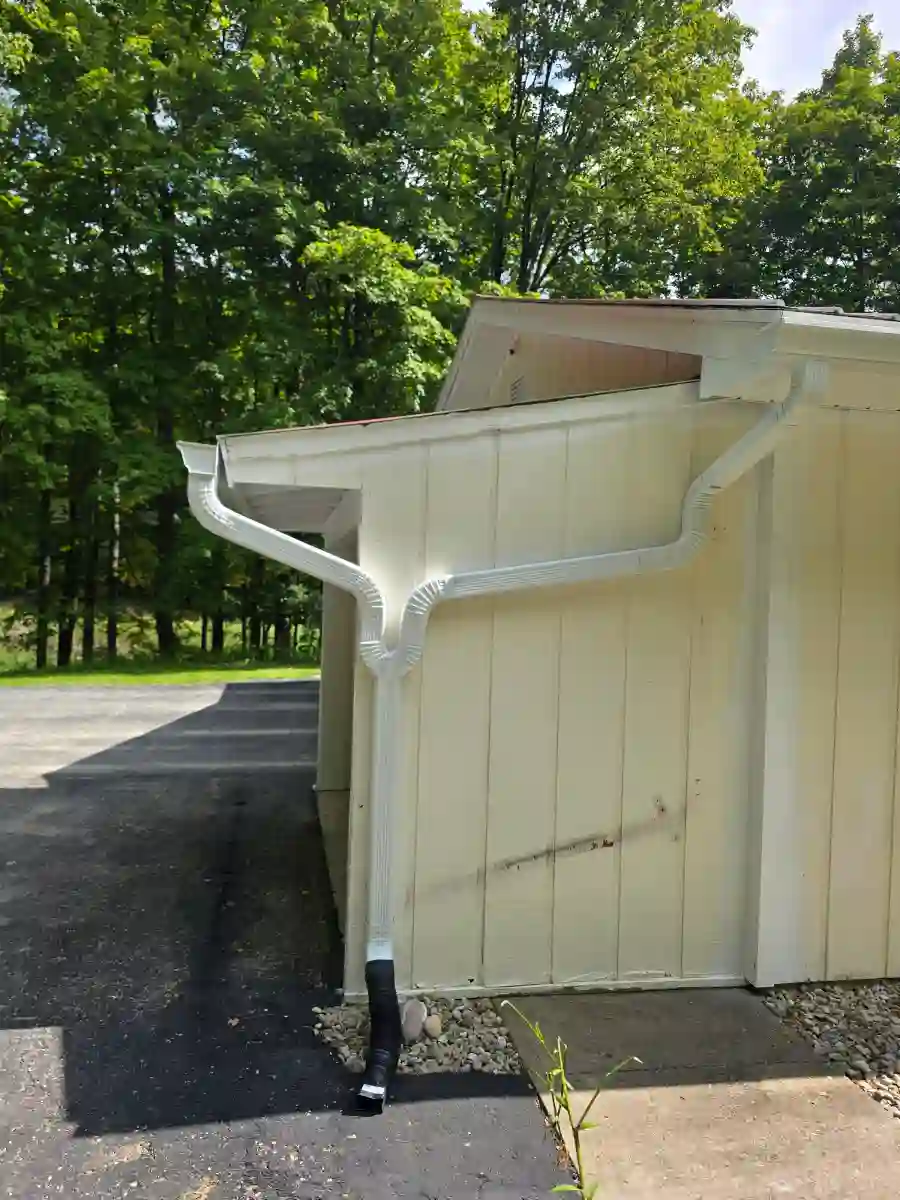 White seamless gutter and downspout on a white garage