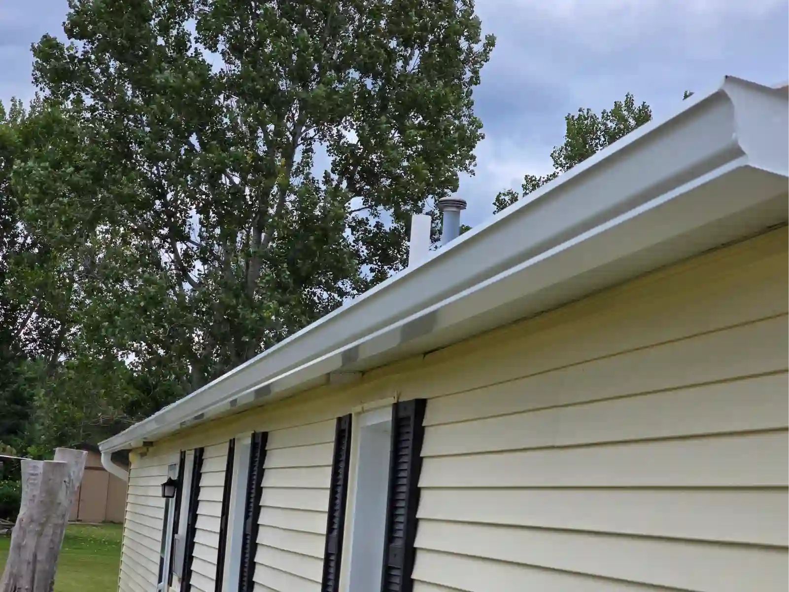 Seamless gutters along the eaves of a sided home