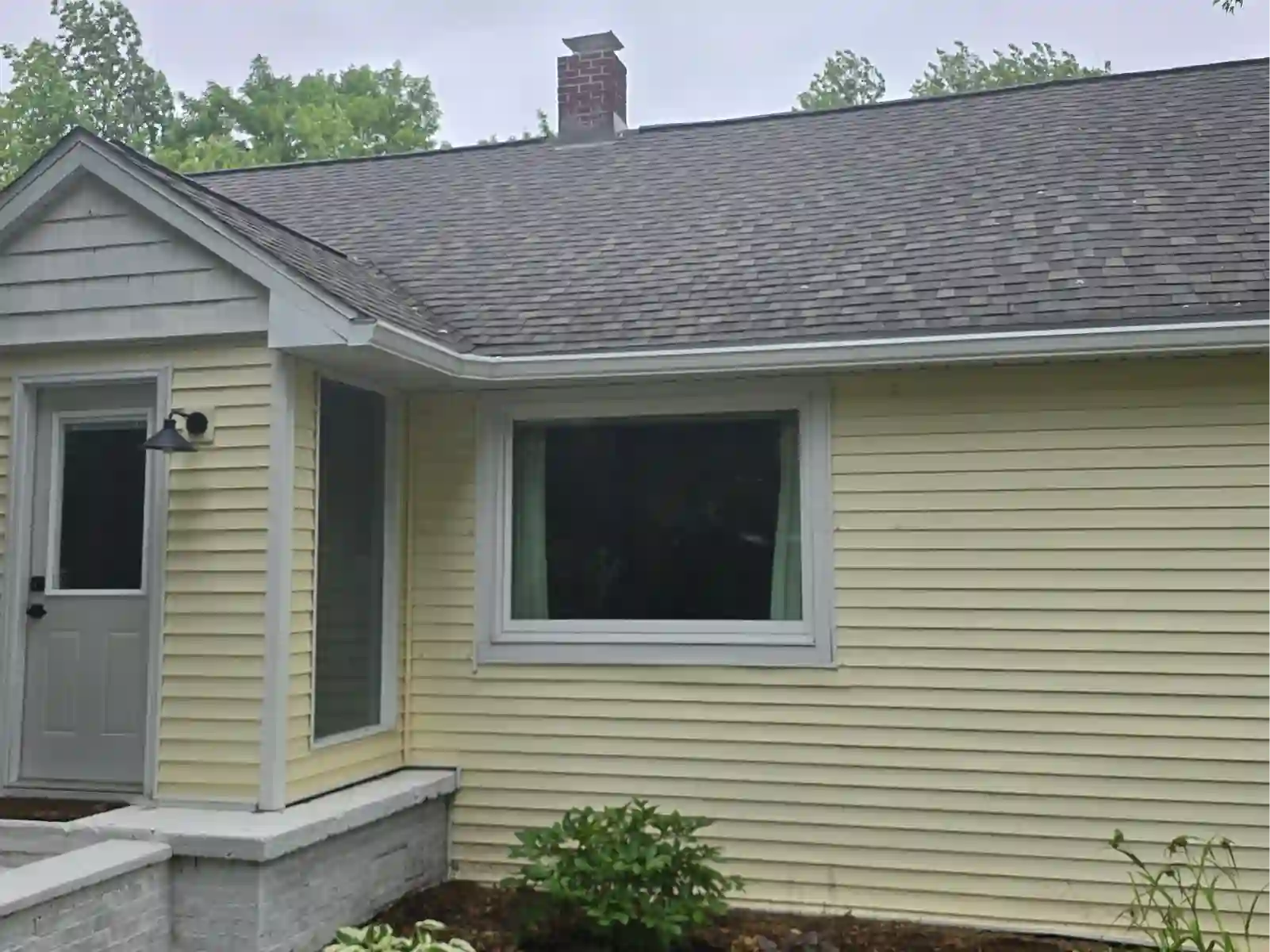 Shingle roof over a pale yellow ranch home