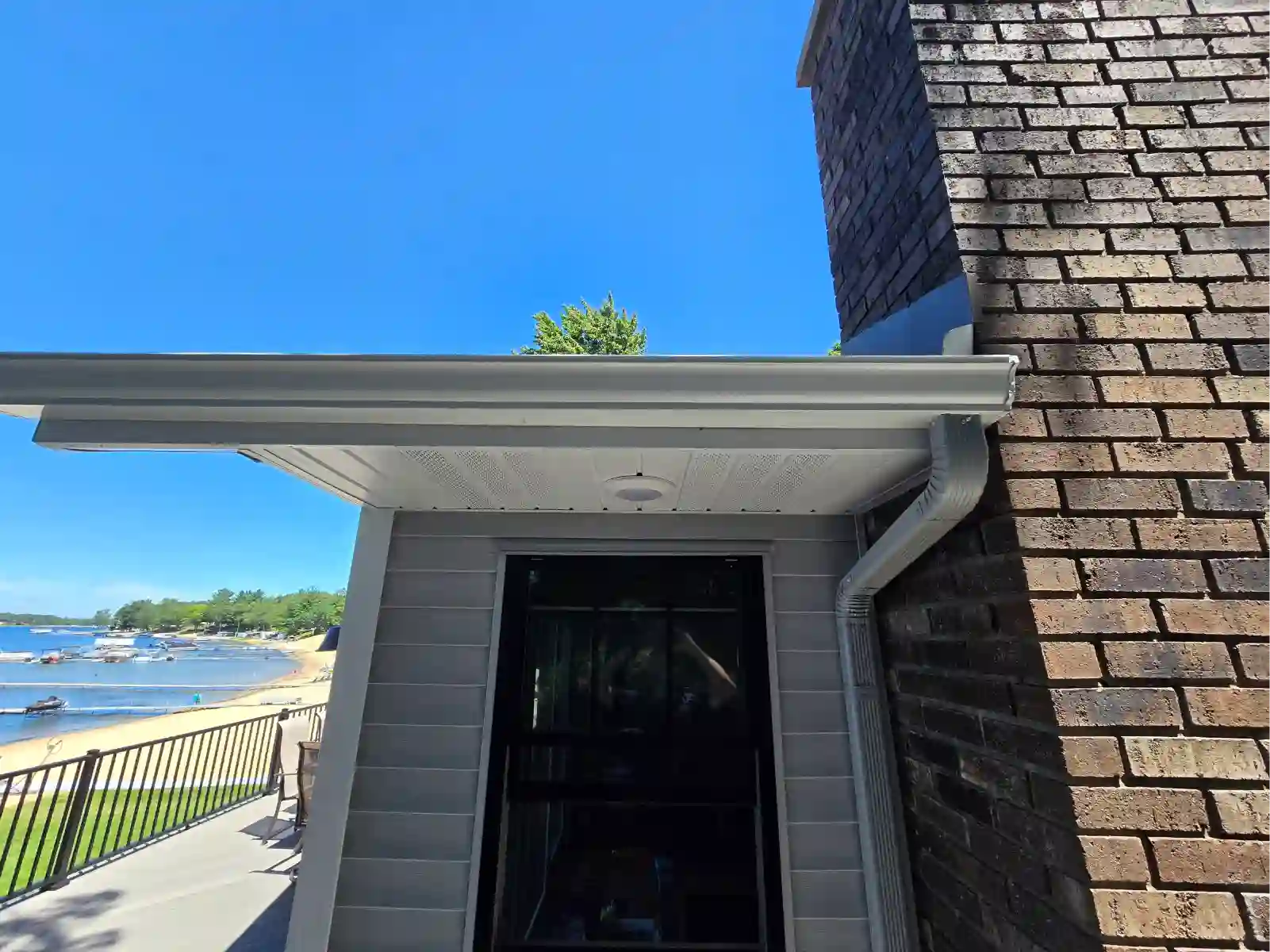 Lakefront home with white gutter and downspout
