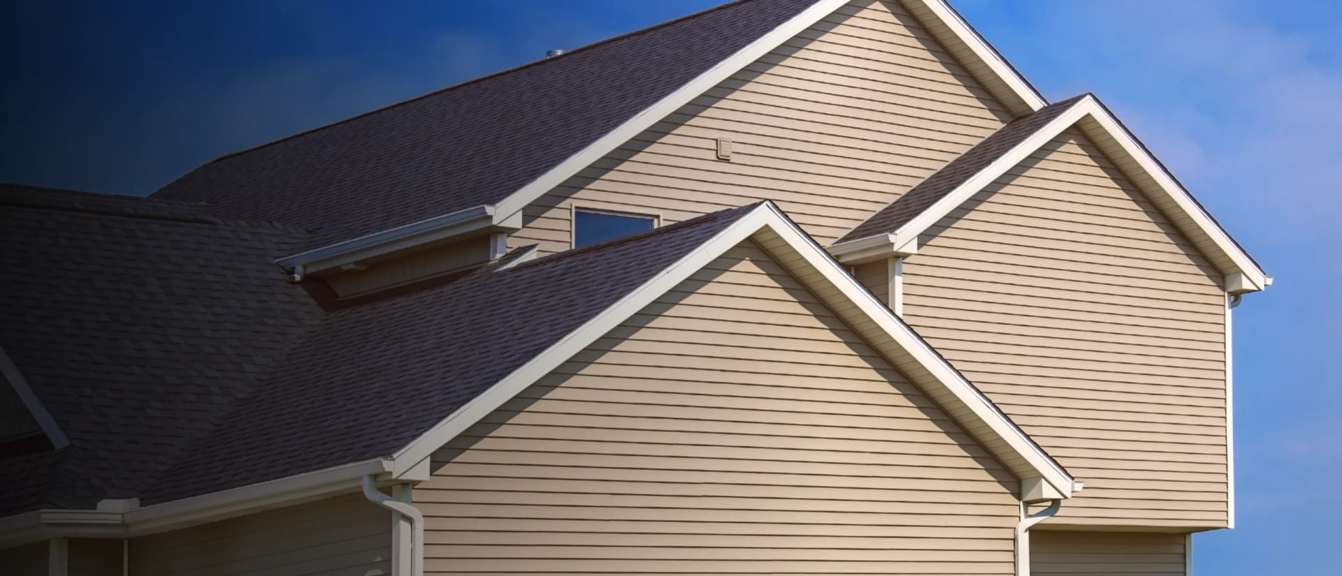 Asphalt shingle roof with multiple gables and white trim